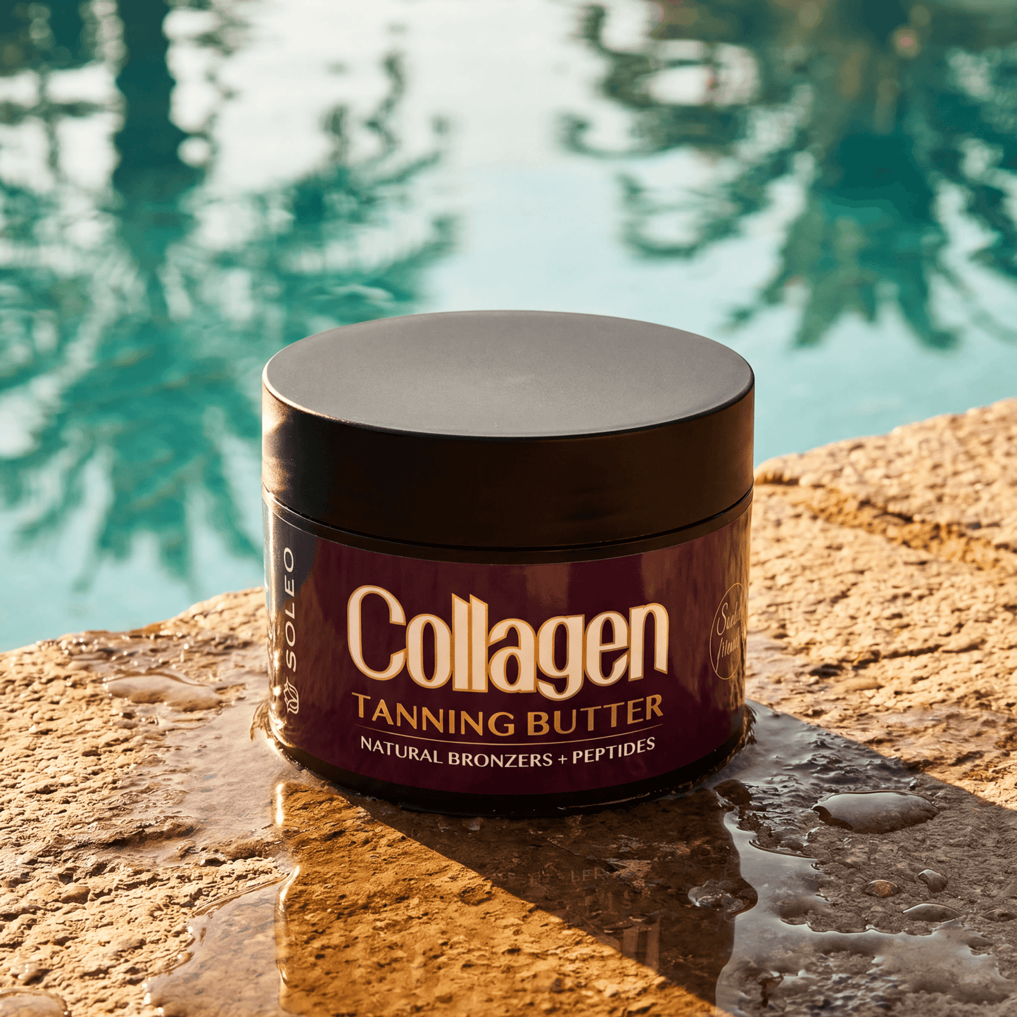 Soleo tanning butter jar on wet stone surface near turquoise pool water