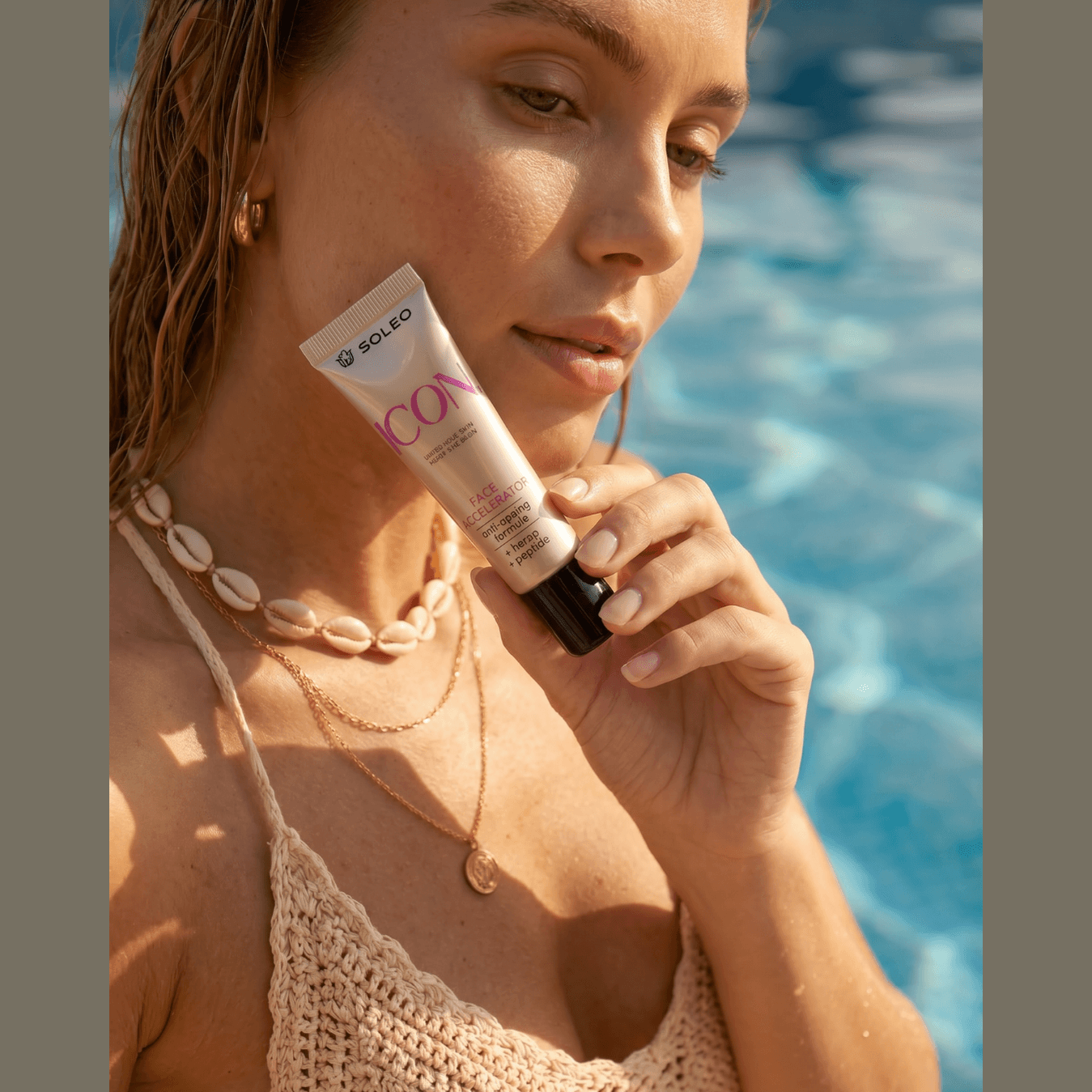 Soleo Icon Face Accelerator tube held by woman in pool, anti-aging tanning lotion with hemp and peptides