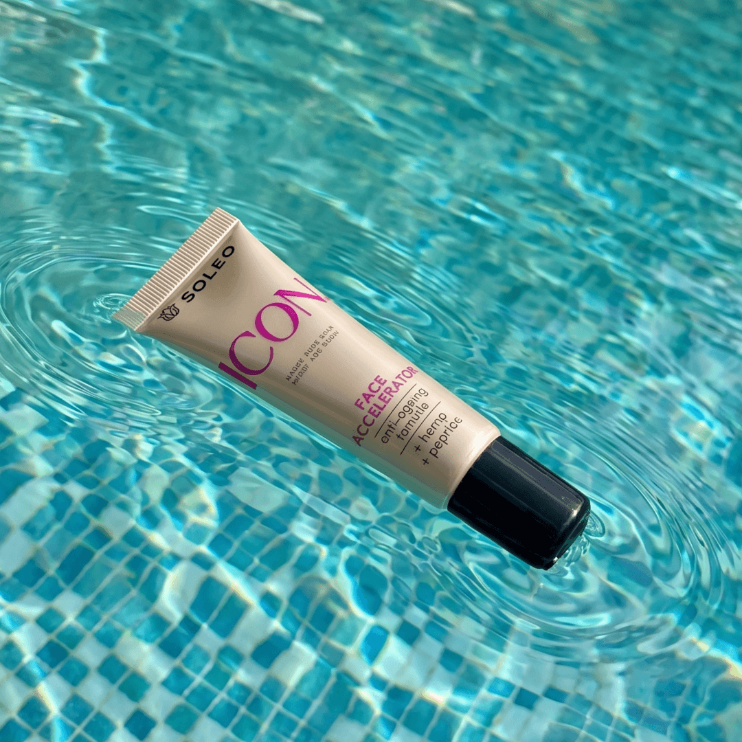 Gold Soleo Icon Face Accelerator tube floating in clear blue pool water, reflective surface highlights