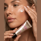 Woman applying Soleo Icon Face Accelerator cream to cheek, hydrating solarium lotion with peptides